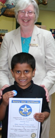 Proudly holding his badge and certificate is Huzaifah Hayat with Rotarian Pam Spokes