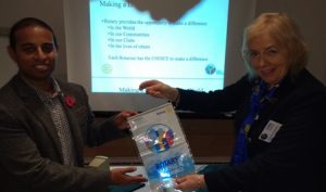 District Governor Chris Davies presents her Making A Difference banner to Novus President Elect Jason Chauhan