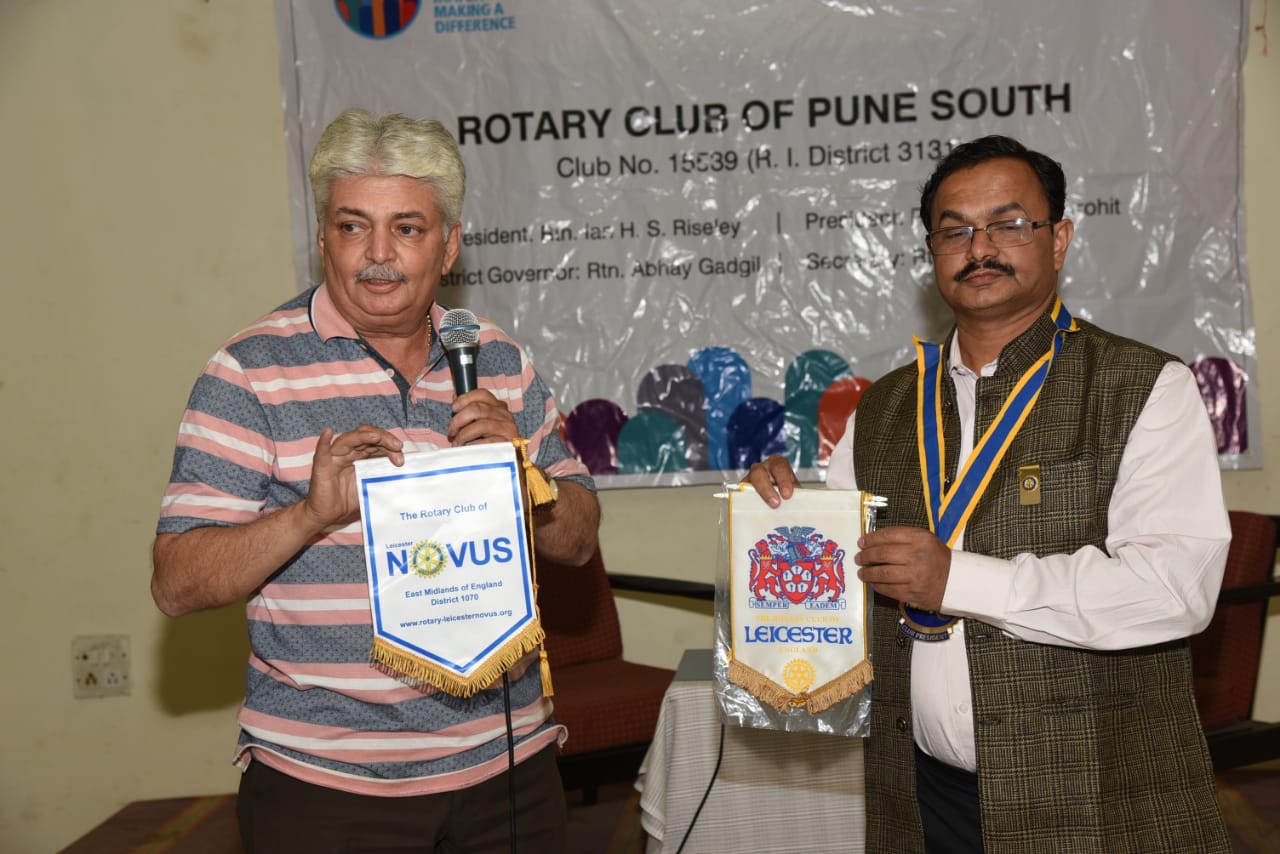 Rtn Viren Shah presents to Kiran Purohit, president of the Rotary Club of Pune the banners of the Rotary Club of Leicester and the Rotary Club of Leicester Novus which he received when he visited Novus