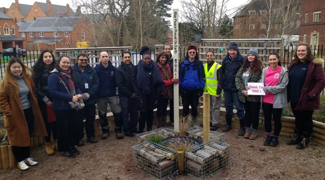 Head teacher and Novus Rotary member Jasbir Mann holds the Peace Pole with the hedge-planting volunteers