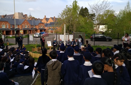 Falcons Primary School children look on as Rotary members sit in the Peace Garden