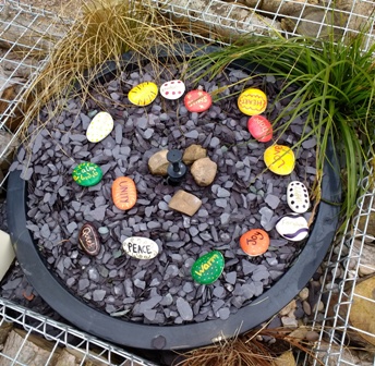 Peace. Unity. Warm. Love. Health. Some of the stones painted with words pupils say sum up the meaning of Peace. The stones were placed in the water feature of the Rotary Peace Garden