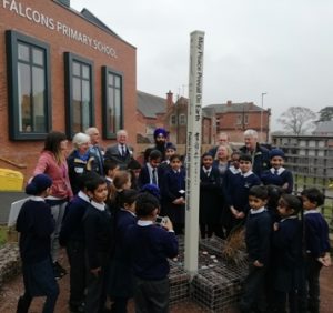 Falcons Primary School pupils showing RIBI staff, governor and Rotarians the Peace Pole which is the centrepiece of the Peace Garden