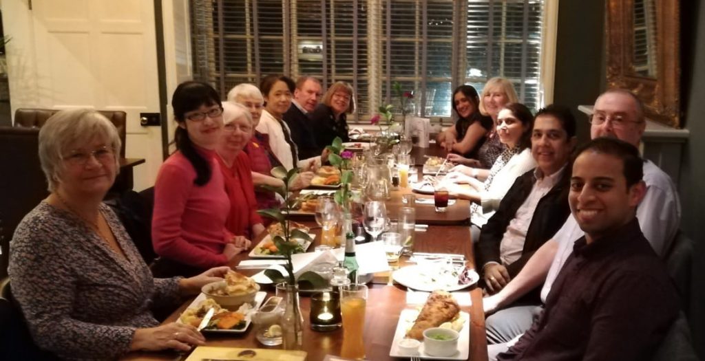 Mai Tsumura and her mother seated  with members and guests of the Rotary Club of Leicester Novus around a dining table