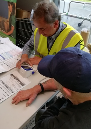 Volunteer Ranjit Mann records the blood pressure of an Asda shopper